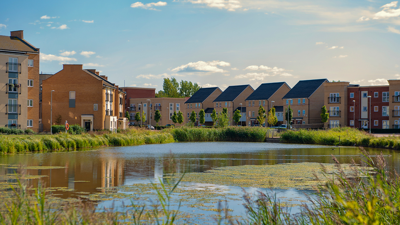 A new Basildon Town housing development surrounding a large pond.